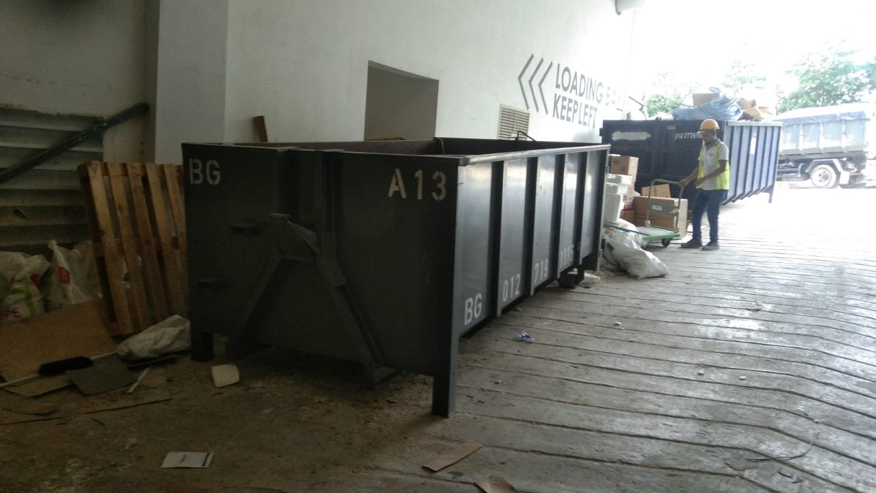 a man standing in front of a large metal container